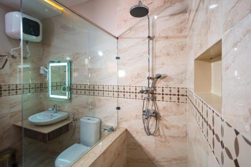 ein Bad mit einer Dusche, einem Waschbecken und einem WC in der Unterkunft Wali's Suites in Abuja