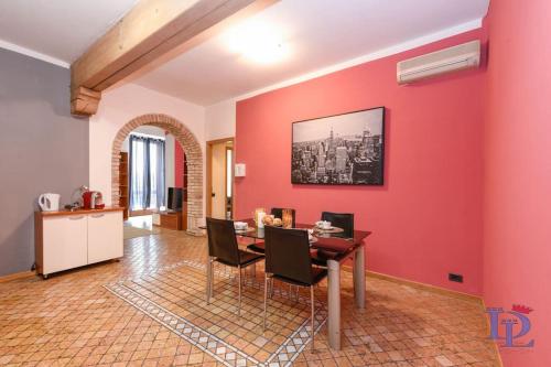 a living room with a red wall and a table and chairs at DesenzanoLoft Let It Be A Dream in Desenzano del Garda