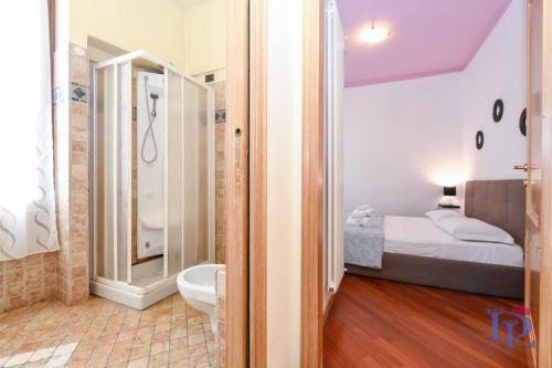 ein Schlafzimmer mit einem Bett und ein Badezimmer mit einer Dusche in der Unterkunft DesenzanoLoft Let It Be A Dream in Desenzano del Garda