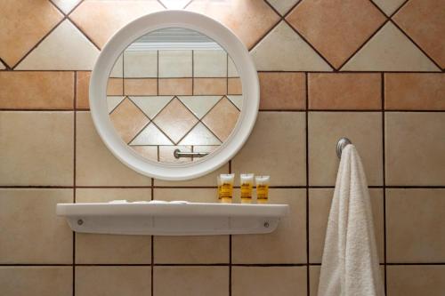 a bathroom with a mirror and a sink at Kapahi Magic Hotel Apartments in Potos