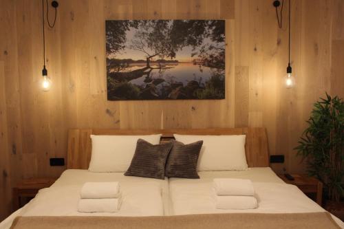 a bedroom with a large bed with a painting on the wall at FerienWohnung SeeUfer am Plöner See in Ascheberg