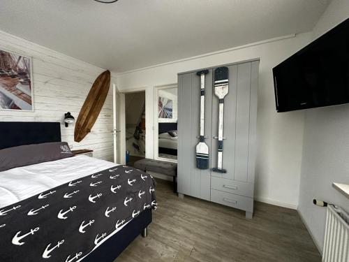 a bedroom with a bed and a flat screen tv at Bootshaus Appartements in Cuxhaven