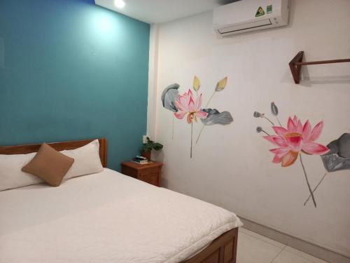 a bedroom with a bed with flowers on the wall at Sông Suối Homestay in Quy Nhon
