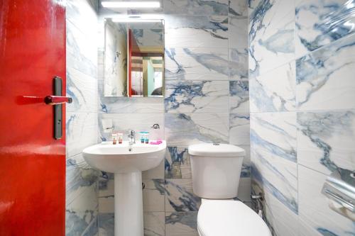 a bathroom with a toilet and a sink and a mirror at Hotel Central Club Sofia in Sofia