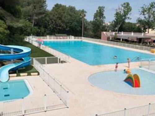 une grande piscine avec un parasol arc-en-ciel dans l'eau dans l'établissement T2 avec Wi-Fi, Parking Privé, Piscine et Tennis à 200m des Plages et Commerces - FR-1-316-259, à Six-Fours-les-Plages
