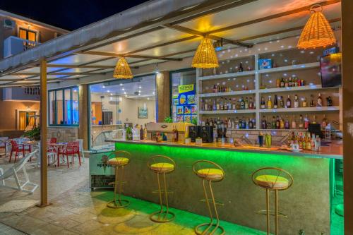 a green bar with stools in a restaurant at Kozanos Hotel & Suites in Amoudi