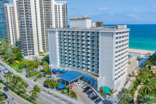 an aerial view of a large white building with the ocean at Ramada Plaza by Wyndham Marco Polo Beach Resort in Miami Beach