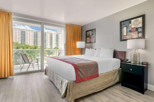 a hotel room with a large bed and a balcony at Ramada Plaza by Wyndham Marco Polo Beach Resort in Miami Beach