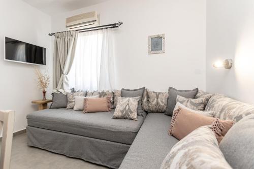 a living room with a gray couch with pillows at Arhontiko in Naxos Chora