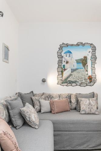 a living room with a gray couch with a mirror on the wall at Arhontiko in Naxos Chora