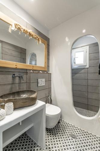 a bathroom with a sink and a toilet and a mirror at Arhontiko in Naxos Chora
