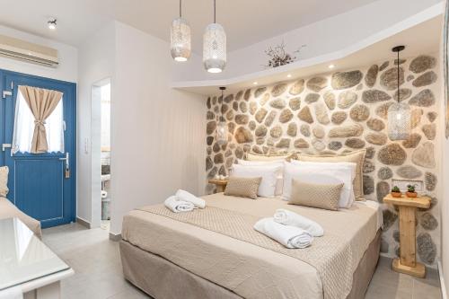 a bedroom with a large bed and a stone wall at Arhontiko in Naxos Chora