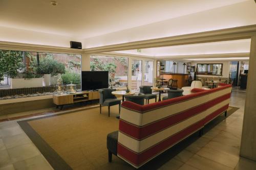 a living room with a couch and a television at Hotel Subur Maritim in Sitges