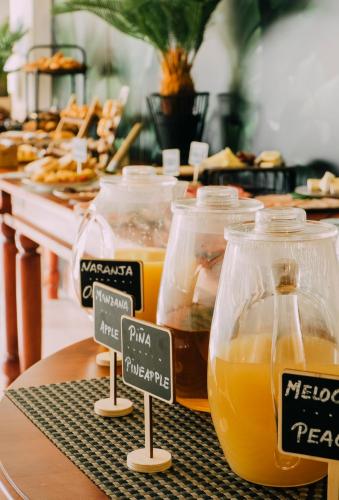 a table with several jars of orange juice and bread at Hotel Subur Maritim in Sitges