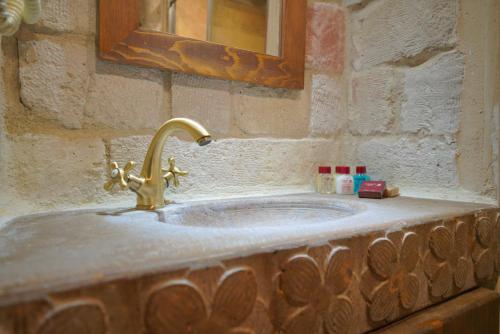 a bathroom sink with a gold faucet at Fairyland Cave Hotel in Goreme