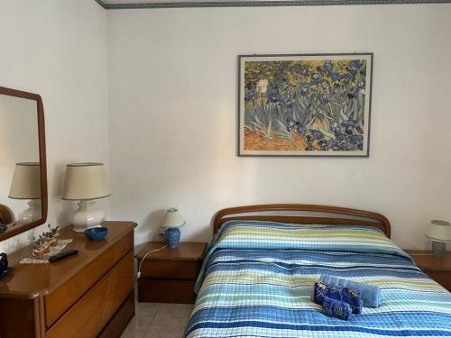a bedroom with a bed and a painting on the wall at Appartamento al mare in Porto Santo Stefano