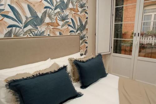 a bed with two pillows sitting next to a window at Luxury Old Town SP7 in Málaga