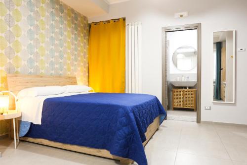 a bedroom with a blue bed and a yellow curtain at Le stanze di Mami in Salerno