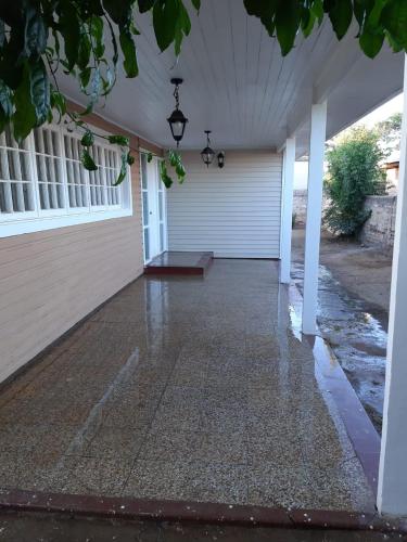 une terrasse couverte à l'avant d'une maison avec de l'eau au sol dans l'établissement Casa Santa María, à Pichilemu
