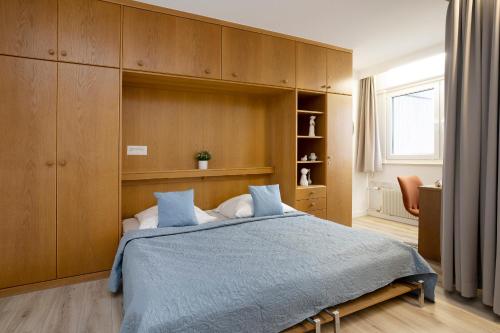 - une chambre avec un grand lit et des placards en bois dans l'établissement Berolina Wohnung 212, à Dahme