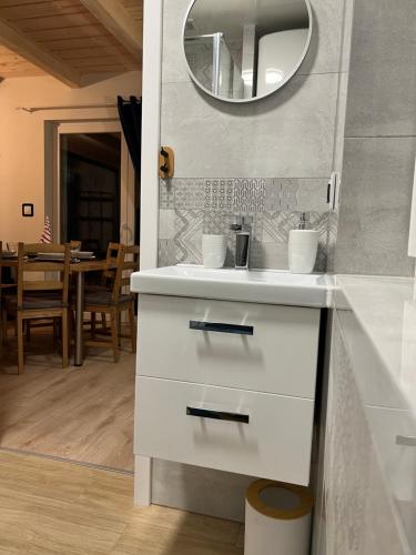 ein Badezimmer mit einem weißen Waschbecken und einem Spiegel in der Unterkunft Domki na Stoku in Wisła