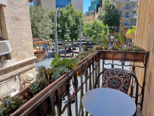 un balcón con una mesa y una silla y algunas plantas en Jerusalem Hostel en Jerusalem