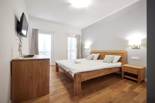 um quarto com uma cama e uma televisão de ecrã plano em Sunset Boutiqe Apartment Old Town Zadar em Zadar