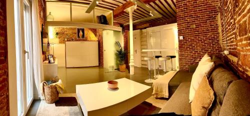 a living room with a couch and a table at calle Amparo100 Red brick loft for 8 Madrid Lavapies in Madrid