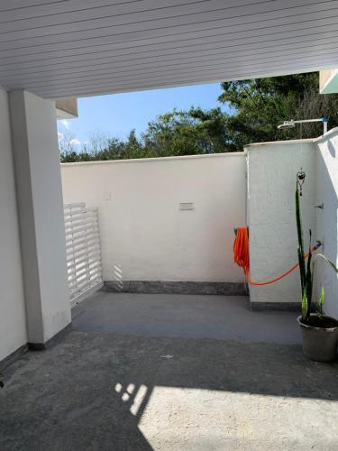 a white wall with an orange hose attached to it at Studio Tranquilo in Florianópolis