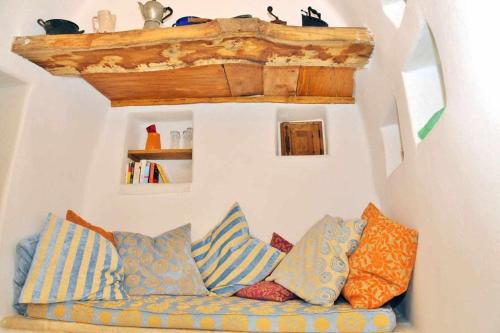 a couch with colorful pillows sitting in a room at Trullo Fragnelli in Cisternino