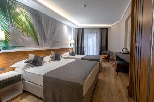 een hotelkamer met 2 bedden en een bureau bij Alba Resort Hotel in Side