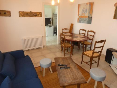 un salon avec une table et un canapé bleu dans l'établissement Appartement T3 avec terrasses et parking privé en centre-ville de Royan, à 200m de la plage - FR-1-71-90, à Royan