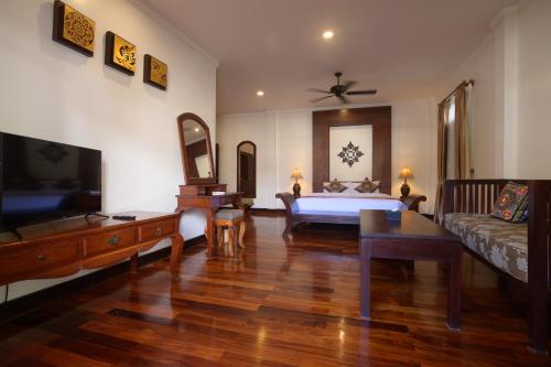 ein Wohnzimmer mit einem Bett und einem Sofa in der Unterkunft Lux Hotel in Luang Prabang