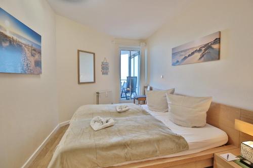 沙博伊茨Residenz Ostseestrand Appartement 22的一间卧室配有一张大床,上面有两双鞋