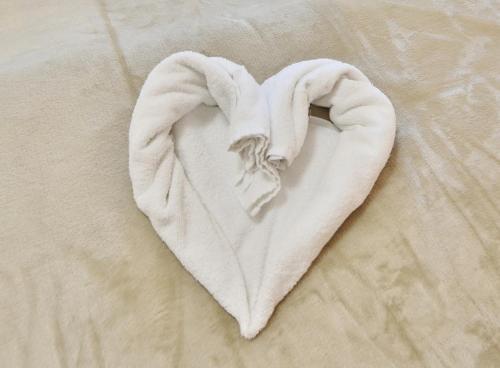 沙博伊茨Residenz Ostseestrand Appartement 22的床上的白色毛巾,呈心形