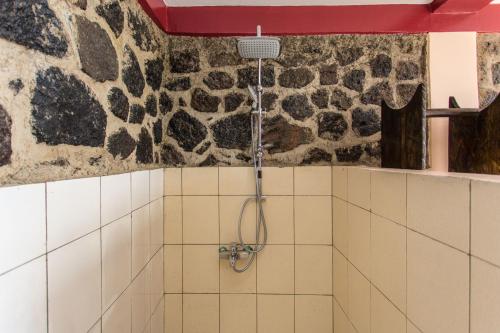 a shower in a bathroom with a stone wall at Nirvana Heights Hotel in Gisenyi