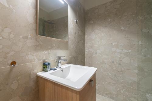 y baño con lavabo blanco y espejo. en Phaedrus Living Luxury Flat Ampelokipoi, en Atenas