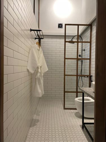 a white robe hanging on a wall in a bathroom at Abode Bombay in Mumbai