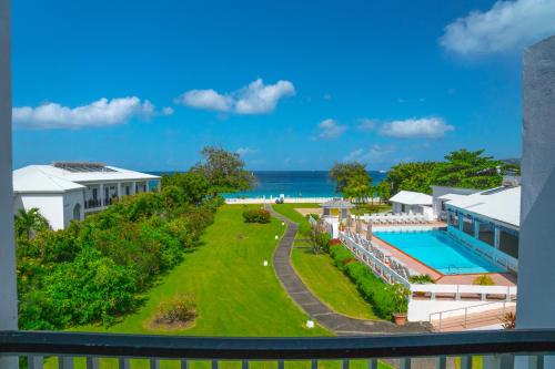 an aerial view of a resort with a swimming pool and the ocean at Allamanda Beach Resort in Grand Anse