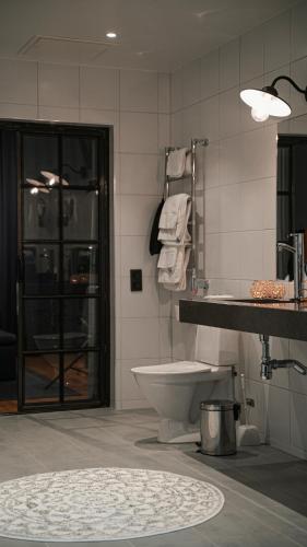 a bathroom with a toilet and a sink at Clarion Hotel Winn in Gävle