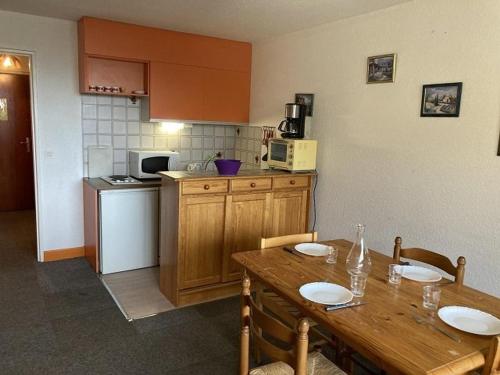 une cuisine avec une table en bois, des chaises, une table et une table dans l'établissement Studio lumineux 4 pers, pieds des pistes, balcon sud, proche sports et commerces - FR-1-262-171, à Orcières