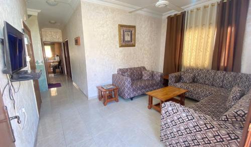 a living room with two couches and a table at Abo Amer Apartments in Aqaba