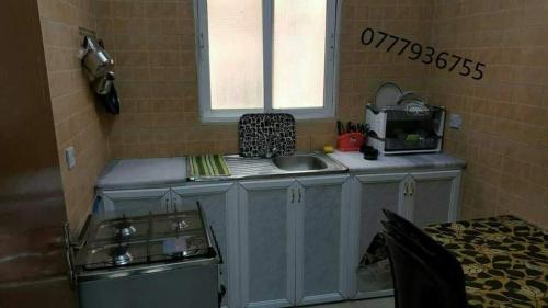 a small kitchen with a sink and a window at Abo Amer Apartments in Aqaba