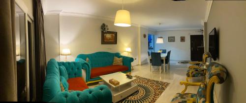 een woonkamer met een blauwe bank en een tafel bij Cozy in Giza 2 bedroom apartment in Caïro