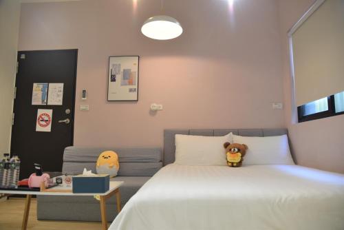 a bedroom with a bed with stuffed animals on it at 竹南橘子民宿 in Zhunan