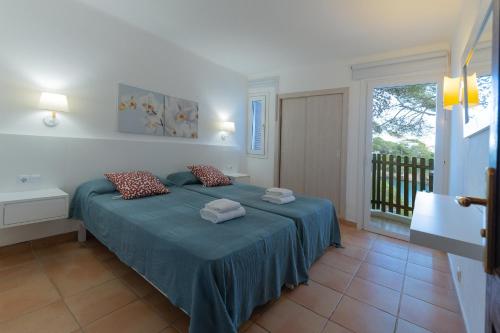 una camera da letto con un letto con due asciugamani sopra di Apartamento Ferrera Park 305 a Cala Ferrera