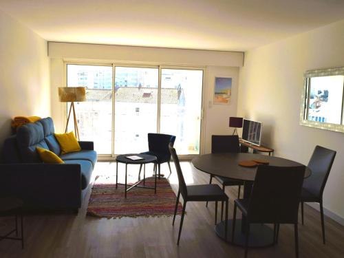 un salon avec un canapé bleu et une table dans l'établissement Appartement 1 chambre, garage, accès direct plage - FR-1-197-527, à Les Sables-dʼOlonne
