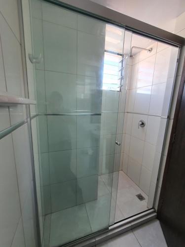 een douche met glazen deuren in de badkamer bij Céntrico monoambiente en el prado in Cochabamba