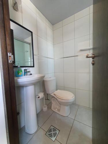 La salle de bains est pourvue de toilettes, d'un lavabo et d'un miroir. dans l'établissement Céntrico monoambiente en el prado, à Cochabamba