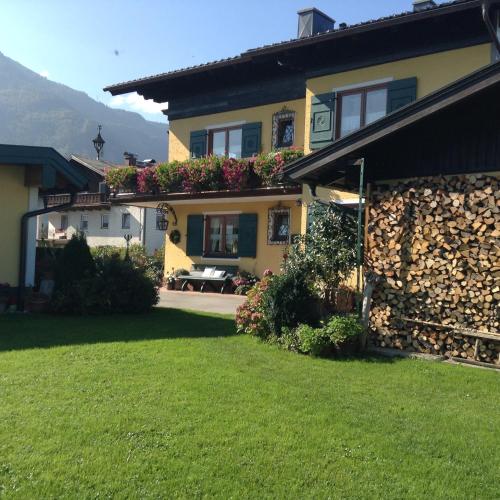 a house with a stone wall next to a yard at Ferienwohnung Neureiter in Golling an der Salzach
